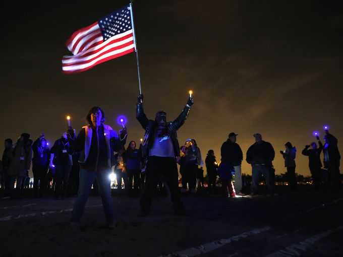 In Midland Beach, Staten Island. A resident raises the flag. Photo Credit: Getty Images