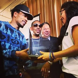 Chance giving out laptops  at the #getconnected event at Chicago's Alcott Prep. Ludacris looks on.